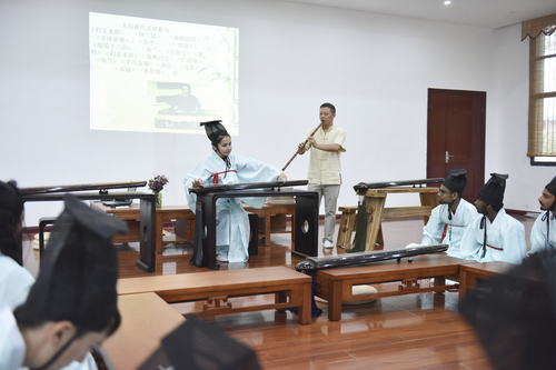 6月21日，德信在线官网国学院，古乐老师欧阳平彪与来自塔吉克斯坦的留学生sayora（佑娜）在合奏《高山流水》。 李谌涵 摄